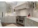 Gourmet kitchen with stainless steel range, custom hood, marble counters, custom cabinets, and herringbone backsplash at 2305 Whiting Bay Cts, Kennesaw, GA 30152