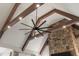 High ceiling and fan with exposed beam details in an open concept room with a stone fireplace at 2305 Whiting Bay Cts, Kennesaw, GA 30152