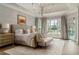 Elegant primary bedroom featuring a tray ceiling, chandelier, and view of the backyard at 2305 Whiting Bay Cts, Kennesaw, GA 30152