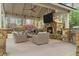 Outdoor living space with a stone fireplace, TV, grill, and comfortable seating at 2305 Whiting Bay Cts, Kennesaw, GA 30152