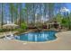 Inviting backyard pool area with surrounding stone patio and waterfall feature at 2305 Whiting Bay Cts, Kennesaw, GA 30152
