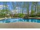 Stunning swimming pool with waterfall feature, mature landscaping, and lounge chairs at 2305 Whiting Bay Cts, Kennesaw, GA 30152