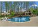Luxurious curved swimming pool with a stone waterfall and outdoor living area and seating at 2305 Whiting Bay Cts, Kennesaw, GA 30152