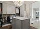 Luxurious walk-in closet with custom cabinetry, marble island, and elegant chandelier lighting at 2305 Whiting Bay Cts, Kennesaw, GA 30152