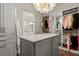 Well-organized walk-in closet with abundant hanging space, custom cabinets, and an elegant chandelier at 2305 Whiting Bay Cts, Kennesaw, GA 30152