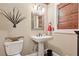 Elegant powder room features a pedestal sink, decorative mirror, and bamboo window shade at 5533 Woodridge Ln, Douglasville, GA 30135
