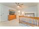 Well-lit bedroom with a dresser, a ceiling fan, comfortable carpet, and a view of the hallway at 825 Clarion Way, Lawrenceville, GA 30044