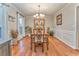 Dining room with dark hardwood floors, wainscotting, and view of a bright window at 825 Clarion Way, Lawrenceville, GA 30044