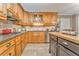 Close up on kitchen with wooden cabinets, tile backsplash, granite countertops and stainless steel appliances at 825 Clarion Way, Lawrenceville, GA 30044