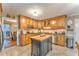 Open kitchen with island, light wood cabinets, stainless appliances, and dining space with exterior view at 825 Clarion Way, Lawrenceville, GA 30044