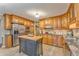 Well-lit kitchen featuring a center island, stainless steel appliances and natural wood cabinetry at 825 Clarion Way, Lawrenceville, GA 30044