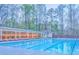 Large community pool with a covered lounging area surrounded by lush trees at 825 Clarion Way, Lawrenceville, GA 30044
