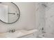 Bathroom features a shower with marble tile, modern vanity, and large round mirror at 2694 Hickory Valley Dr, Snellville, GA 30078