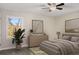Calm bedroom featuring a neutral palette, minimalist decor, large window, and ceiling fan at 2694 Hickory Valley Dr, Snellville, GA 30078