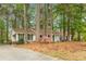 Ranch-style home with white siding, black shutters, and mature trees on a landscaped lot at 2694 Hickory Valley Dr, Snellville, GA 30078