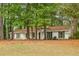 Ranch-style home with white siding, black shutters, and mature trees on a grassy lot at 2694 Hickory Valley Dr, Snellville, GA 30078