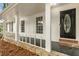 Close up of front porch with painted stone base, white railings, and black decorative front door at 2694 Hickory Valley Dr, Snellville, GA 30078