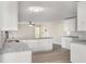 Bright kitchen with granite countertops, white cabinets, and stainless steel sink with modern light fixtures at 2694 Hickory Valley Dr, Snellville, GA 30078