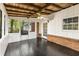Enclosed porch with white paneling, brick accents, wooden ceiling, fan, and screens with dark flooring at 2694 Hickory Valley Dr, Snellville, GA 30078