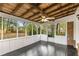 Enclosed porch with white paneling, brick accents, wooden ceiling, fan, and screens with dark flooring at 2694 Hickory Valley Dr, Snellville, GA 30078