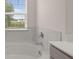 View of the bathroom tub with tile surround and outside view at 1119 Blue Juniper Circle, Loganville, GA 30052