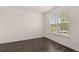 A bright bedroom with vinyl flooring, large window with outside view, and neutral walls at 1119 Blue Juniper Circle, Loganville, GA 30052