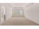 Spacious main bedroom with tray ceiling, neutral carpeting, and large windows allowing natural light at 1119 Blue Juniper Circle, Loganville, GA 30052