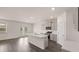 Bright kitchen features an island with a sink, stainless steel appliances, gray cabinets and wood floors at 1119 Blue Juniper Circle, Loganville, GA 30052