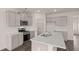 The kitchen includes an island with sink, gray cabinets and stainless steel appliances at 1119 Blue Juniper Circle, Loganville, GA 30052