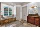 Relaxing bathroom features a soaking tub with travertine surround and natural light at 115 Mount Paran Rdg, Atlanta, GA 30327