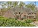 Elegant brick home featuring a manicured lawn, lush greenery, and charming architectural details at 115 Mount Paran Rdg, Atlanta, GA 30327