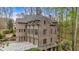 Elegant brick home with multiple garage doors and beautiful architectural details surrounded by lush greenery at 115 Mount Paran Rdg, Atlanta, GA 30327