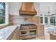 Kitchen showcasing high-end range and hood with marble backsplash, countertops, and sunroom view at 115 Mount Paran Rdg, Atlanta, GA 30327