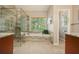 Modern bathroom with glass shower, separate tub, and natural light from a large window at 3130 Crestmont Nw Way, Kennesaw, GA 30152