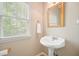 Charming half bath featuring a pedestal sink, large window, and elegant fixtures at 3130 Crestmont Nw Way, Kennesaw, GA 30152