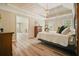 Spacious main bedroom featuring wood floors, tray ceiling, a pendant light, and windows for natural light at 3130 Crestmont Nw Way, Kennesaw, GA 30152