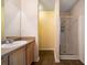 This bathroom has an oak vanity with a sink and mirror, and a glass-enclosed shower at 5556 Cascade Sw Run, Atlanta, GA 30336