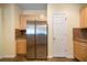Well-lit kitchen featuring stainless steel refrigerator and light wood cabinets at 5556 Cascade Sw Run, Atlanta, GA 30336