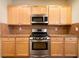 This is a kitchen with stainless steel oven, microwave, light wood cabinets and backsplash at 5556 Cascade Sw Run, Atlanta, GA 30336