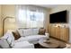 Bright living room with large window, white sofa, wooden cabinet, and mounted television at 70 Sheridan Ne Dr # 10, Atlanta, GA 30305