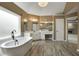 The renovated bathroom features a soaking tub, white cabinets, wood look tile floor, and updated fixtures at 341 Declaire Ne Way, Marietta, GA 30067