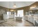 This bathroom boasts a soaking tub, wood look tile floor, glass enclosed shower, chandelier, and double vanities at 341 Declaire Ne Way, Marietta, GA 30067