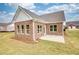 Backyard with a concrete patio and brick exterior featuring multiple windows at 711 Park Place Way, Social Circle, GA 30025