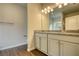 Bright bathroom with dual sinks, granite countertop, wood-look floors, and modern lighting at 711 Park Place Way, Social Circle, GA 30025