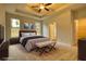 Spacious bedroom with ceiling fan, large windows, and access to the bath, walk in closet, and hallway at 711 Park Place Way, Social Circle, GA 30025