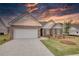 Beautiful exterior of a brick home with a garage and landscaped front yard at sunset at 711 Park Place Way, Social Circle, GA 30025