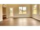 Open-concept living room with laminate flooring, neutral walls, and an abundance of natural light at 711 Park Place Way, Social Circle, GA 30025
