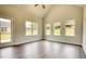 Open living room with laminate floors, large windows offering abundant natural light, and modern trim at 711 Park Place Way, Social Circle, GA 30025