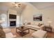 Cozy living room featuring a fireplace, comfortable seating, and a ceiling fan for added comfort at 711 Park Place Way, Social Circle, GA 30025