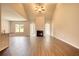 Open-concept living room featuring a fireplace, wood-look floors, and large windows at 711 Park Place Way, Social Circle, GA 30025
